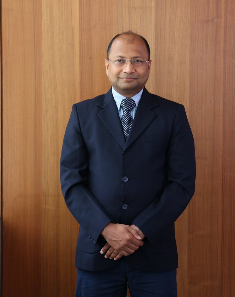 Dr. Ravi Mohanka in a dark suit, standing